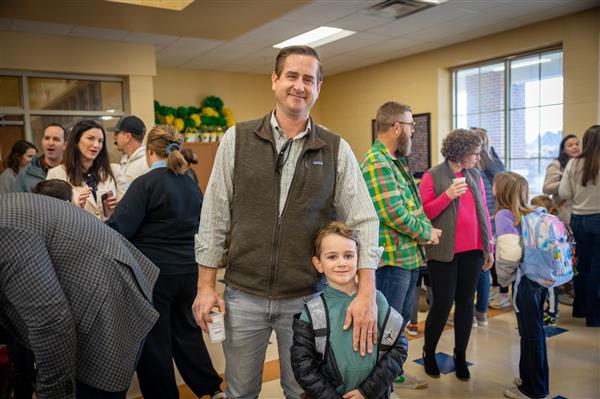 dad and son smiling in crowded cafeteria